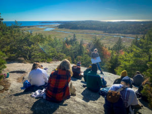 Students sit on rocks overlooking Popham Beach